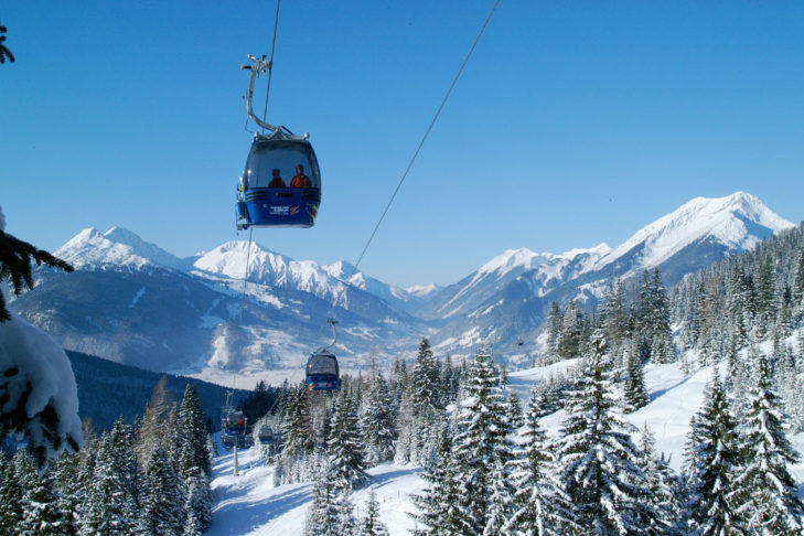 A monocable gondola detachable in front of a wintry landscape.