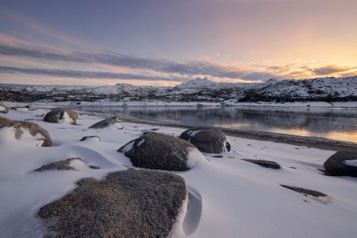 Snow-covered hills meet the sea in Portugal.