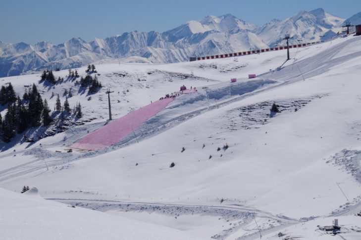 Snowfarming: The accumulated snow hill is covered for the summer.