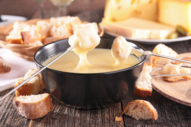 Traditionele kaasfondue is een must voor wintersporters als ze stoppen bij een rustieke hut in een skigebied in Zwitserland