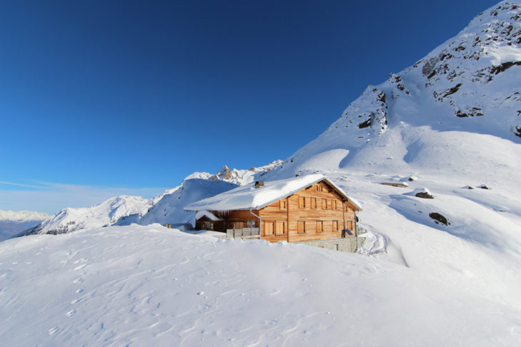 Berghut midden in een besneeuwd landschap: geïsoleerd van het dagelijks leven kun je hier de natuur verkennen.