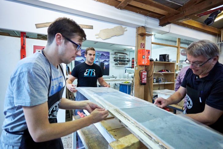 Auf den Holzkern wird eine weitere Glasfaserschicht mit Epoxidharz aufgetragen.