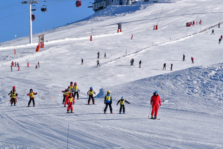 Eine Skischule unterwegs im Skigebiet von Chamrousse.