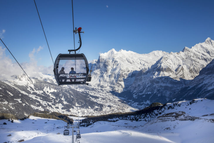 Eine Einseil-Umlaufbahn bzw. Gondel vor winterlicher Kulisse.