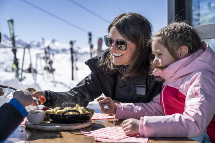 Abseits der Pisten im Skigebiet Silvretta Arena in Ischgl können Familien bei Kindern beliebten Hüttensnacks wie Pommes oder Kaiserschmarrn genießen.