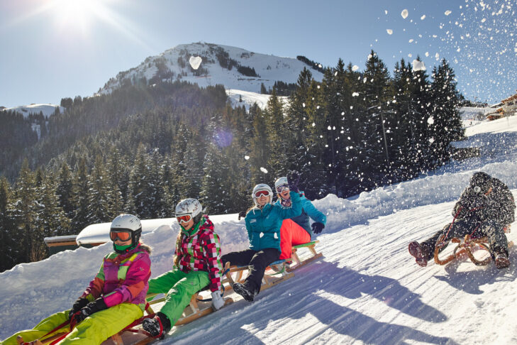 Neben dem Skifahren auf über 200 Pistenkilometern können Familien in der SkiWelt Wilder Kaiser - Brixental auch einige tolle Rodelbahnen auf Schlitten erkunden.