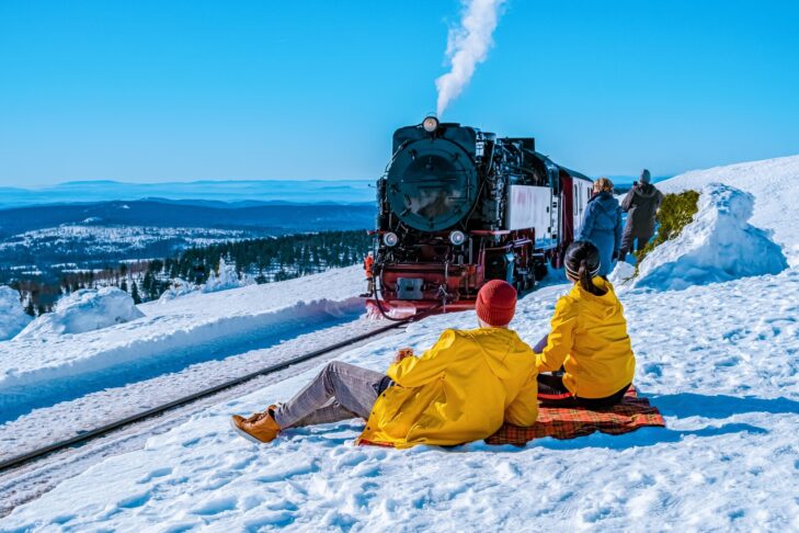 Kłęby pary nad pokrytymi śniegiem torami - legendarna kolej Brockenbahn przemierza góry Harz. SnowTrex przedstawia inne ekscytujące cele wycieczek w górach Harz w tym artykule.