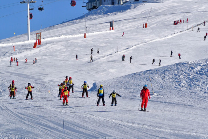 Une école de ski en route sur le domaine skiable de Chamrousse.