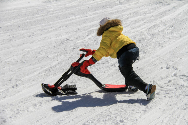 Divertimento allo stato puro: con la snowbike si scende a valle da seduti.