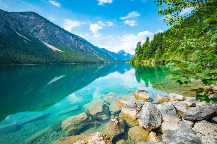 Im klaren Wasser des Plansees spiegelt sich die idyllische Berglandschaft Tirols, was ihn zu einem der schönsten Seen Österreichs macht. 