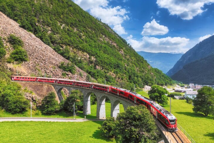 Auf beeindruckenden Viadukten schlängelt sich der Bernina Express durch die traumhaften Alpenlandschaften in der Schweiz.