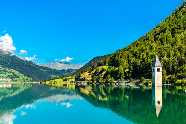 Rund um den Reschensee im Vinschgau führen Wanderwege, von denen aus die Besucher unter anderem einen tollen Blick auf den versunkenen Glockenturm von Graun haben.