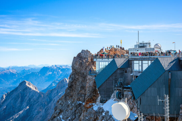 Besucher von Deutschlands höchstem Gipfel können die Bergstation und das goldene Gipfelkreuz etwa mit der Seilbahn Zugspitze erreichen.
