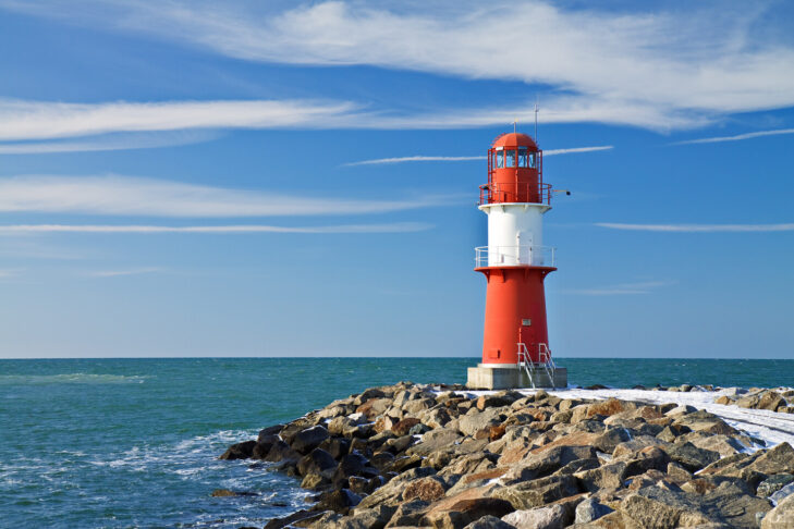 Der Leuchtturm auf der Mole ist für Aktivurlauber am Meer eine der beliebtesten Locations in Warnemünde.
