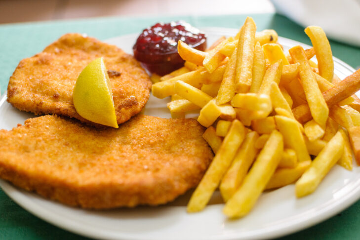 En kulinarisk klassiker: med pommes frites og tyttebær – den wieneriske schnitzel.