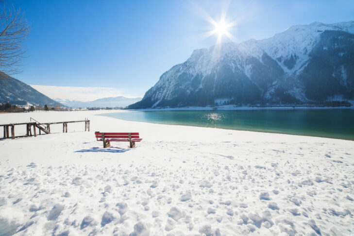 Ein besonders romantisches Panorama beim Winterwandern findet man am, in der Sonne glitzernden, Achensee.