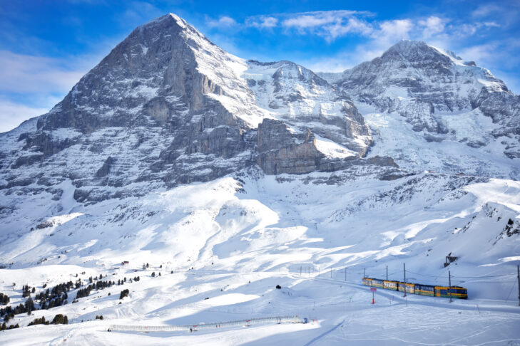 Den verdensberømte nordvæg på Eiger (til venstre, 3.970 m) og Mönch (4.107 m) udgør to tredjedele af den kendte bjergtrio. Trioen fuldendes af Jungfrau (4.158 m), som man endda kan nå med tog i forgrunden på billedet.